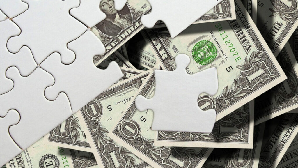puzzle pieces on top of a pile of money