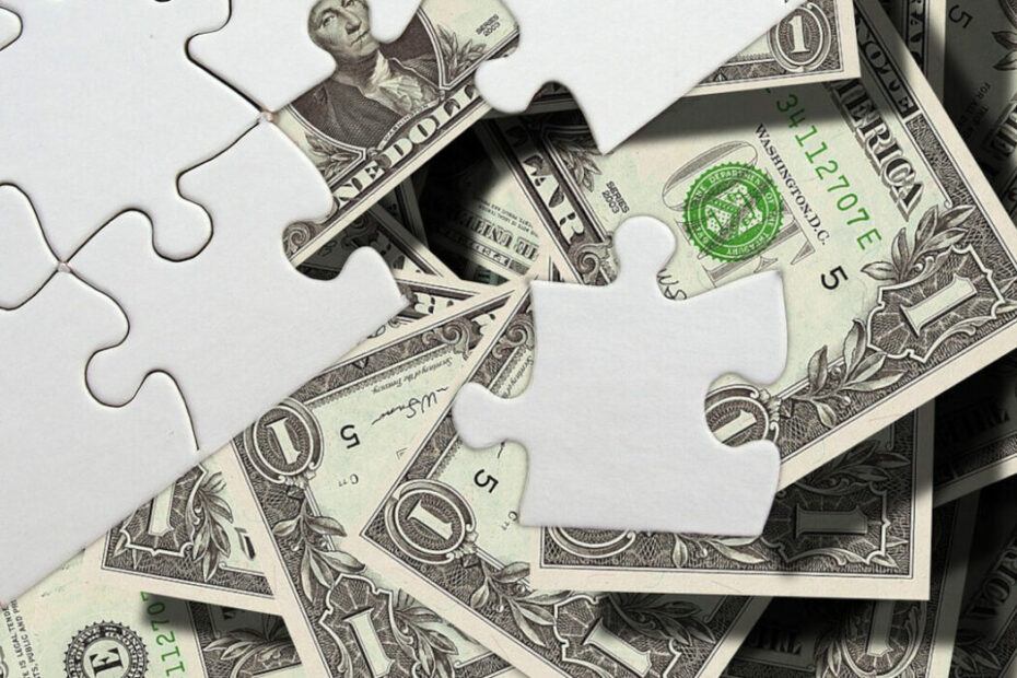 puzzle pieces on top of a pile of money